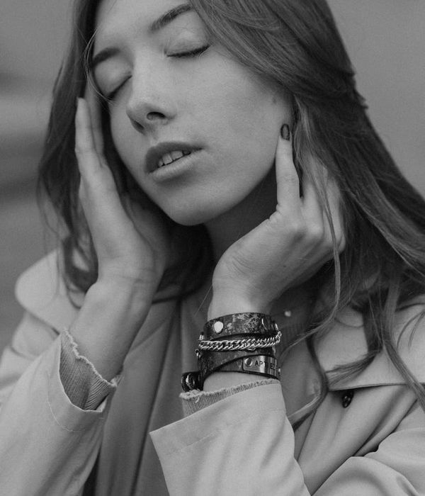 Woman in a calm yoga pose in a dark room with golden light.